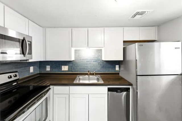 a view of a room with wooden floor and a ceiling fan