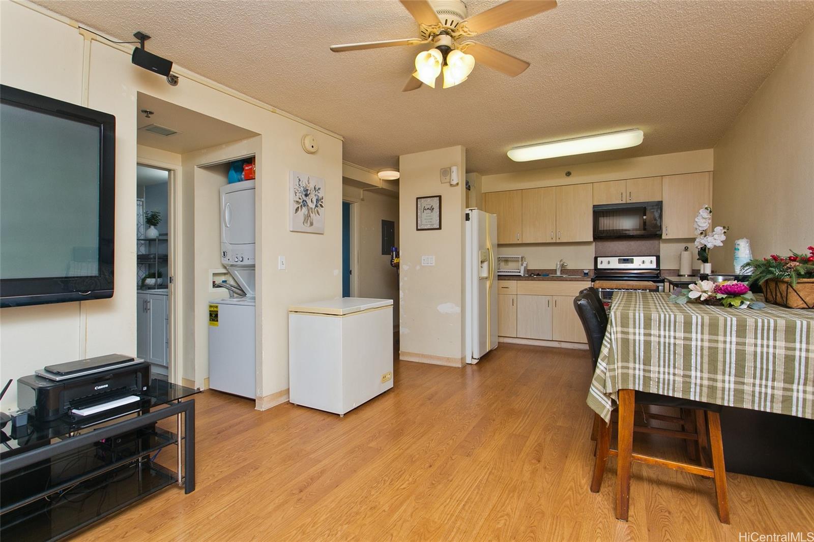 94-302 Paiwa Street, Unit 202 Waipahu, HI 96797 - Photo 4 of 12 a kitchen with stainless steel appliances kitchen island granite countertop a refrigerator and a stove top oven