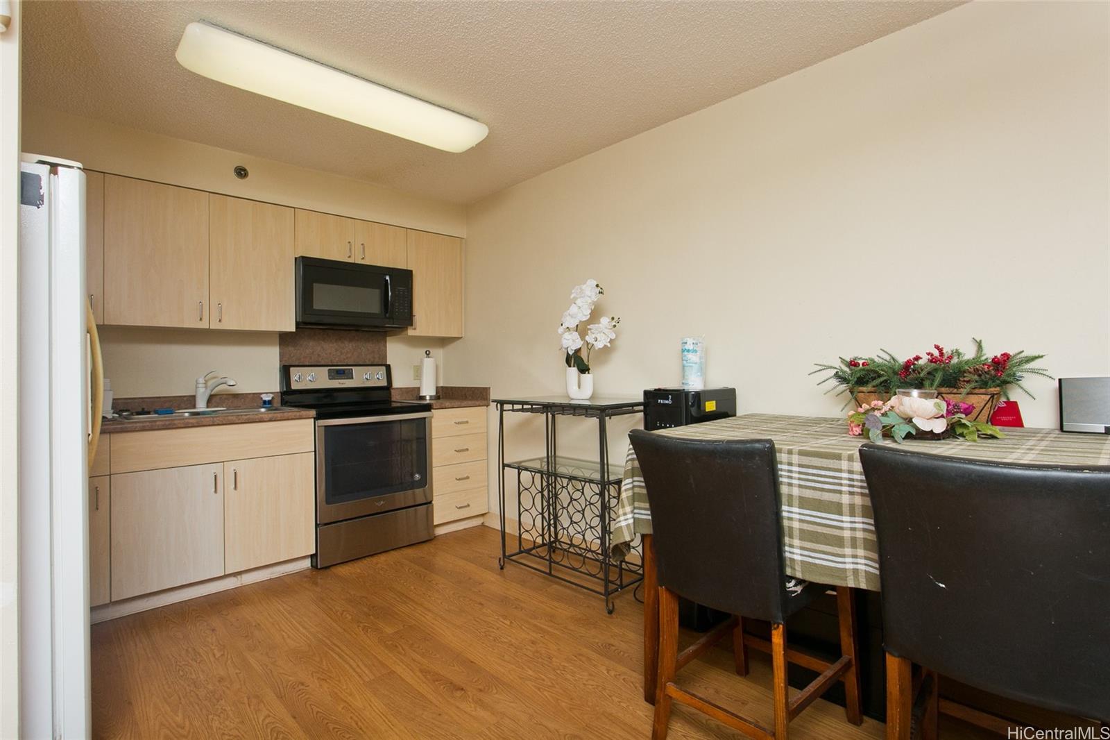 94-302 Paiwa Street, Unit 202 Waipahu, HI 96797 - Photo 5 of 12 a kitchen with a table and chairs