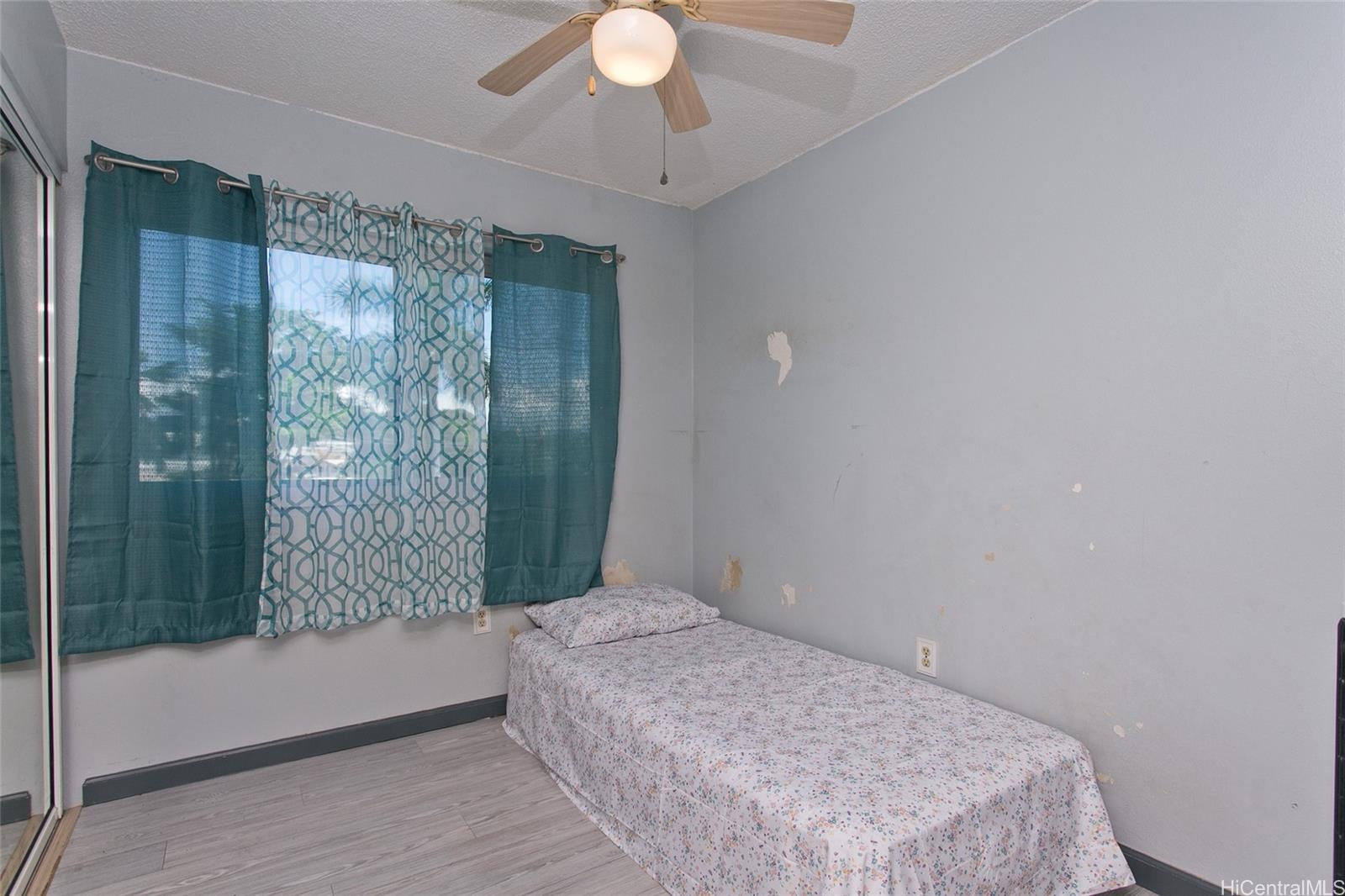 94-302 Paiwa Street, Unit 202 Waipahu, HI 96797 - Photo 6 of 12 a bedroom with a bed and a window