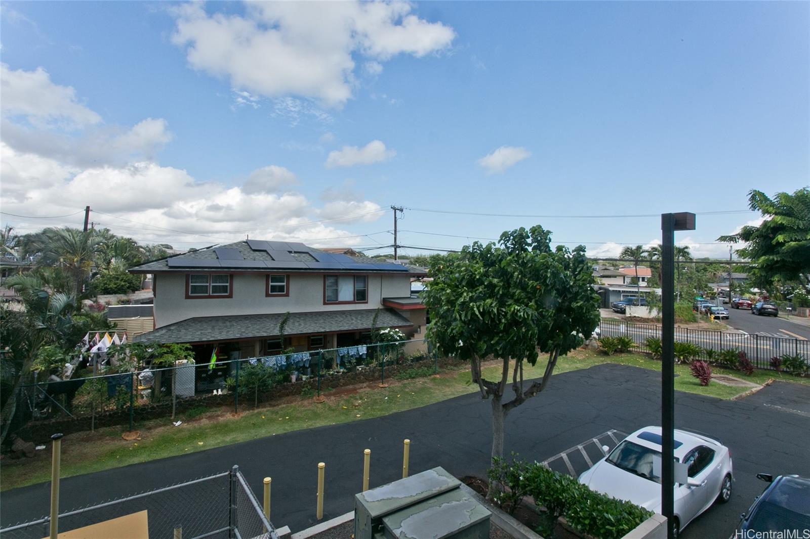 94-302 Paiwa Street, Unit 202 Waipahu, HI 96797 - Photo 10 of 12 a front view of a house with garden