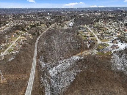 an aerial view of house with yard and mountain view in back