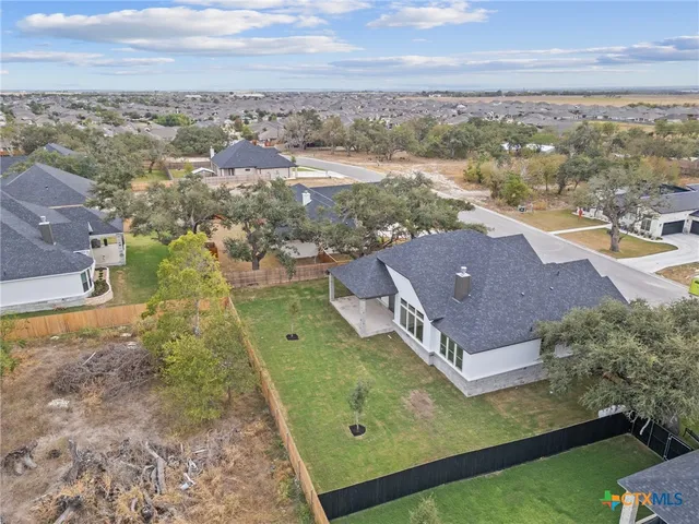 an aerial view of residential houses with outdoor space and ocean view