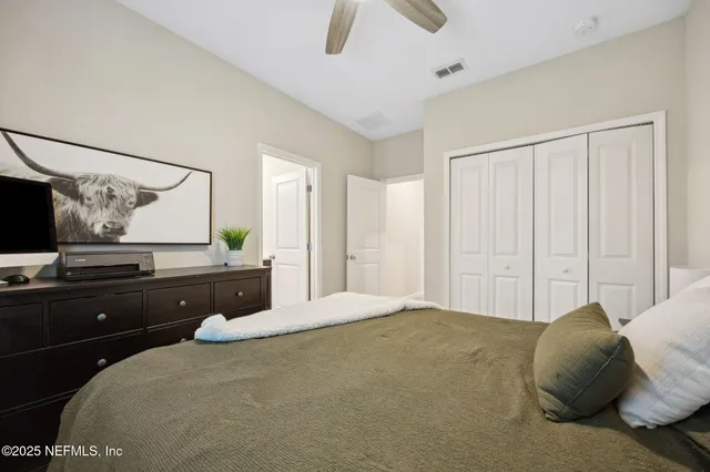a bedroom with a bed and a flat tv screen on dresser