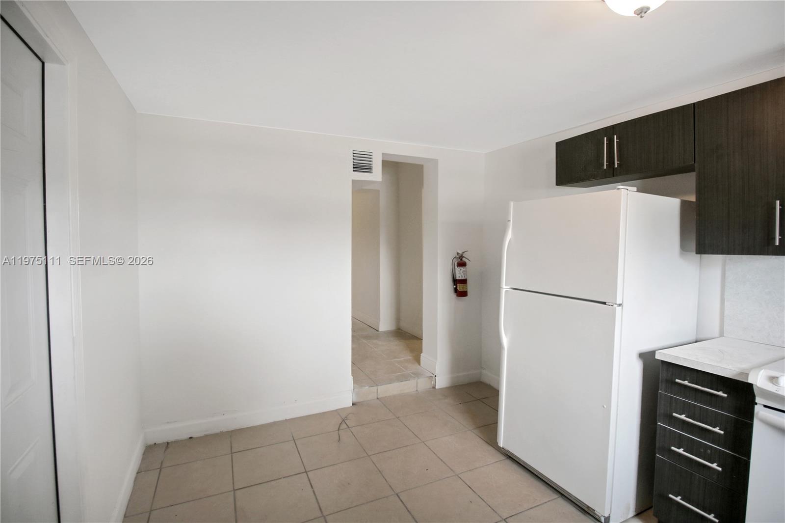 1160 West 26th Court Riviera Beach, FL 33404 - Photo 16 of 40 a white refrigerator freezer and a stove sitting inside of a kitchen