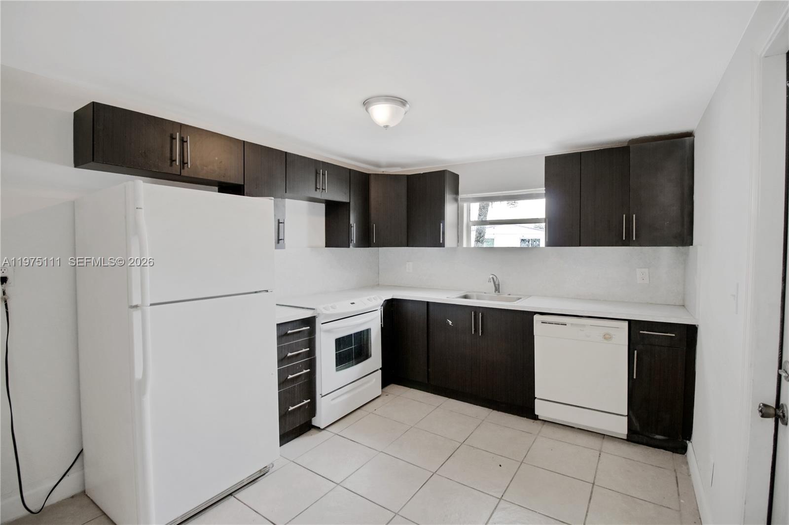 1160 West 26th Court Riviera Beach, FL 33404 - Photo 17 of 39 a kitchen with stainless steel appliances granite countertop a refrigerator and a stove