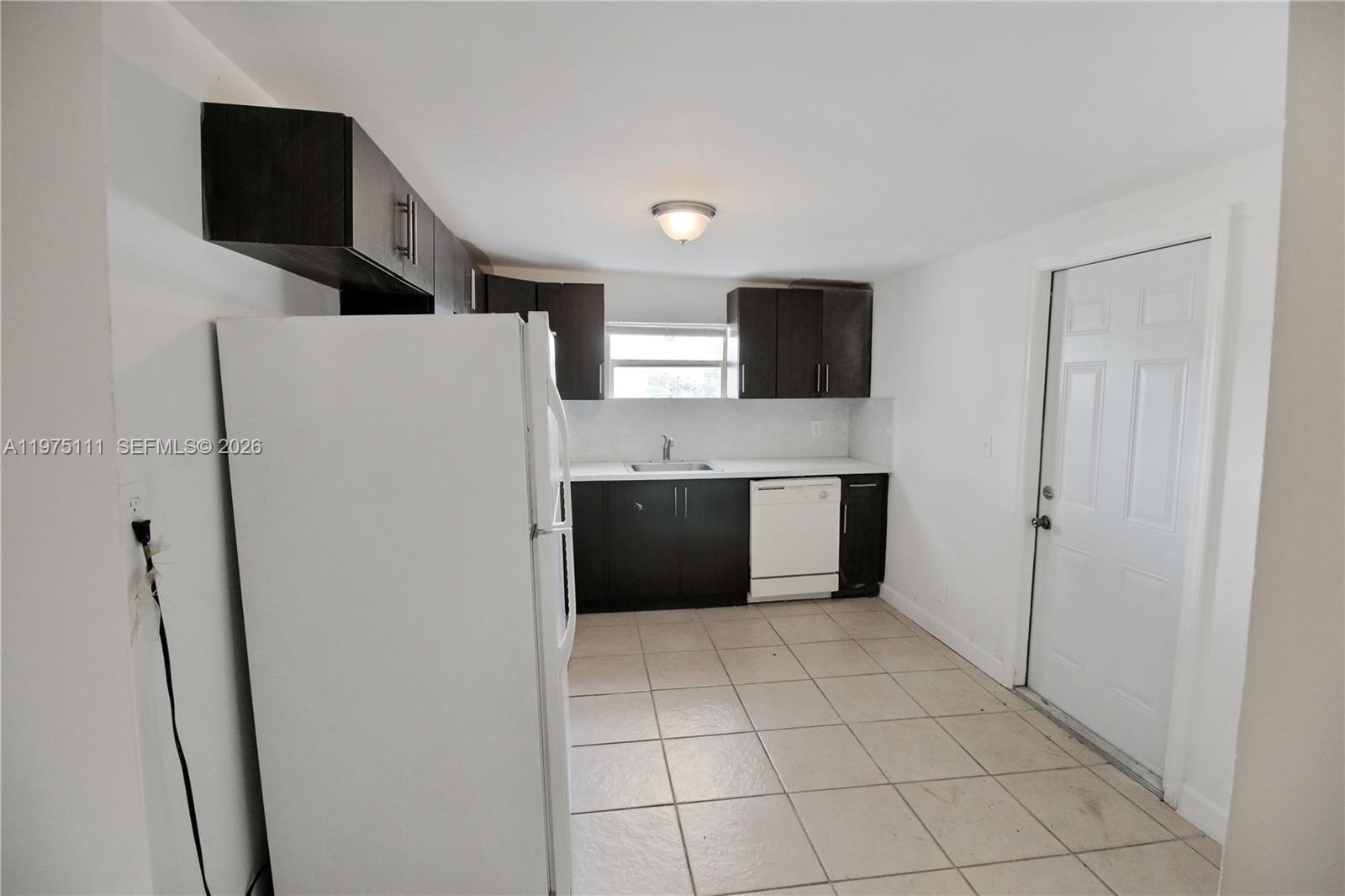 1160 West 26th Court Riviera Beach, FL 33404 - Photo 17 of 40 a kitchen with stainless steel appliances a refrigerator and a sink