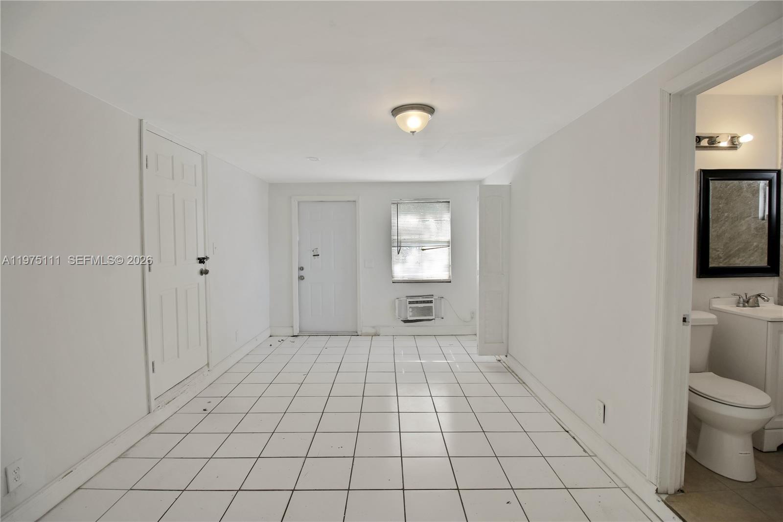 1160 West 26th Court Riviera Beach, FL 33404 - Photo 30 of 40 a bathroom with a toilet a sink a mirror and shower