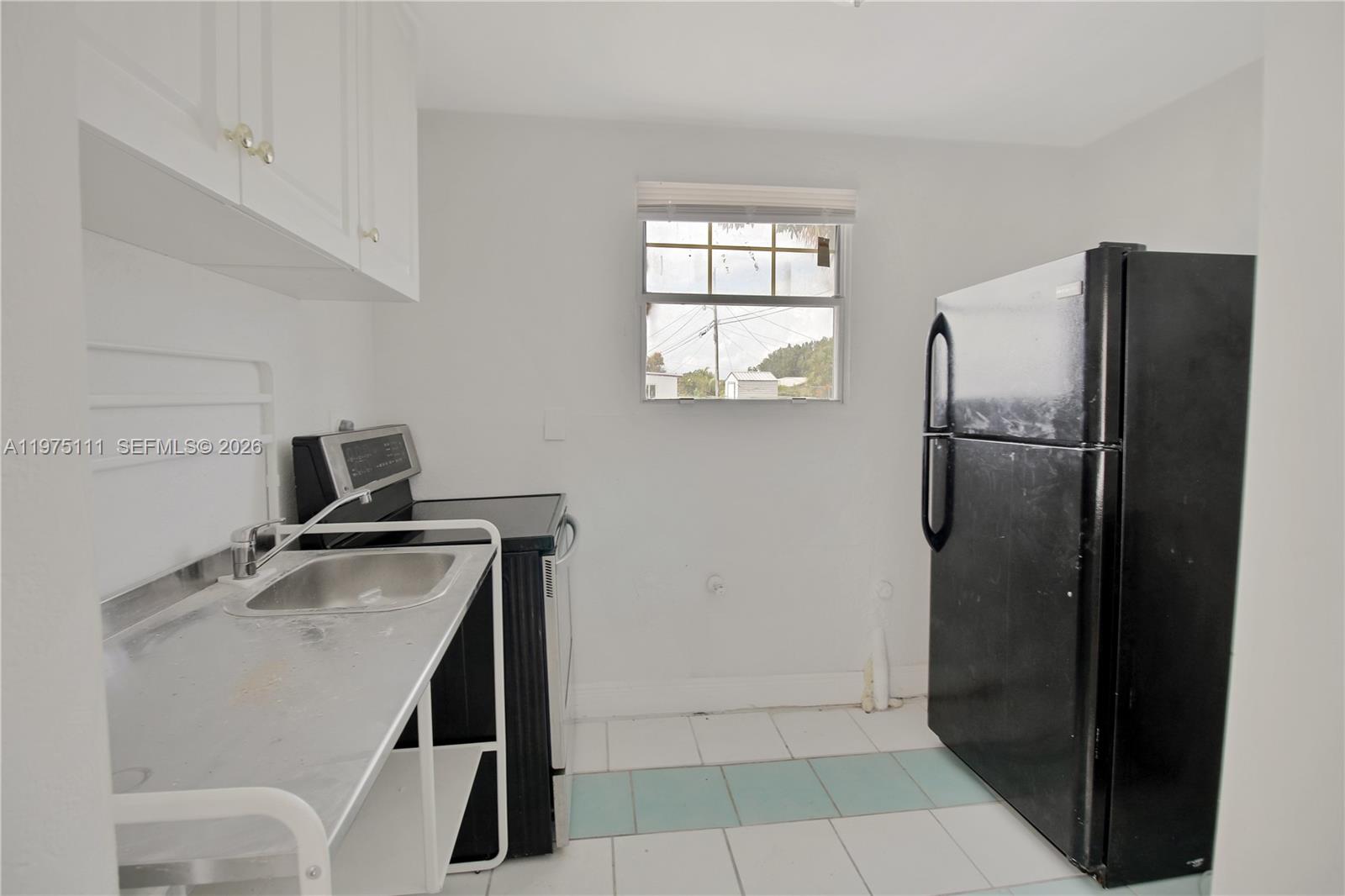 1160 West 26th Court Riviera Beach, FL 33404 - Photo 31 of 40 a kitchen with a refrigerator and a stove top oven