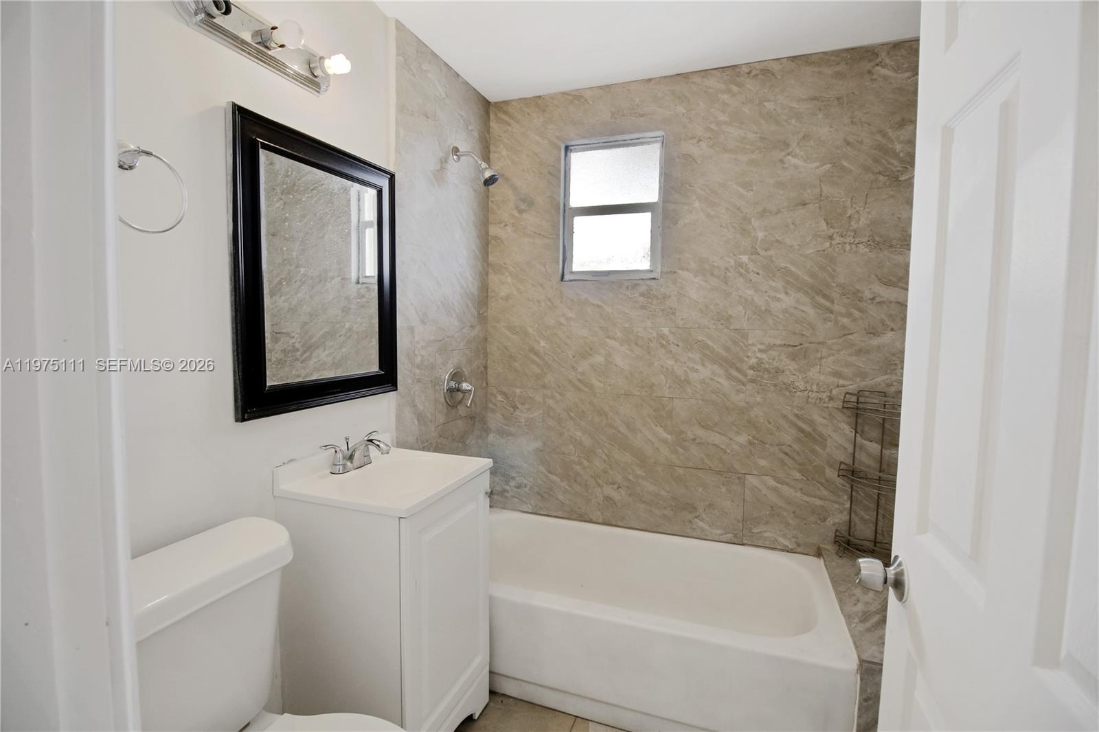 1160 West 26th Court Riviera Beach, FL 33404 - Photo 32 of 39 a bathroom with a toilet sink and mirror