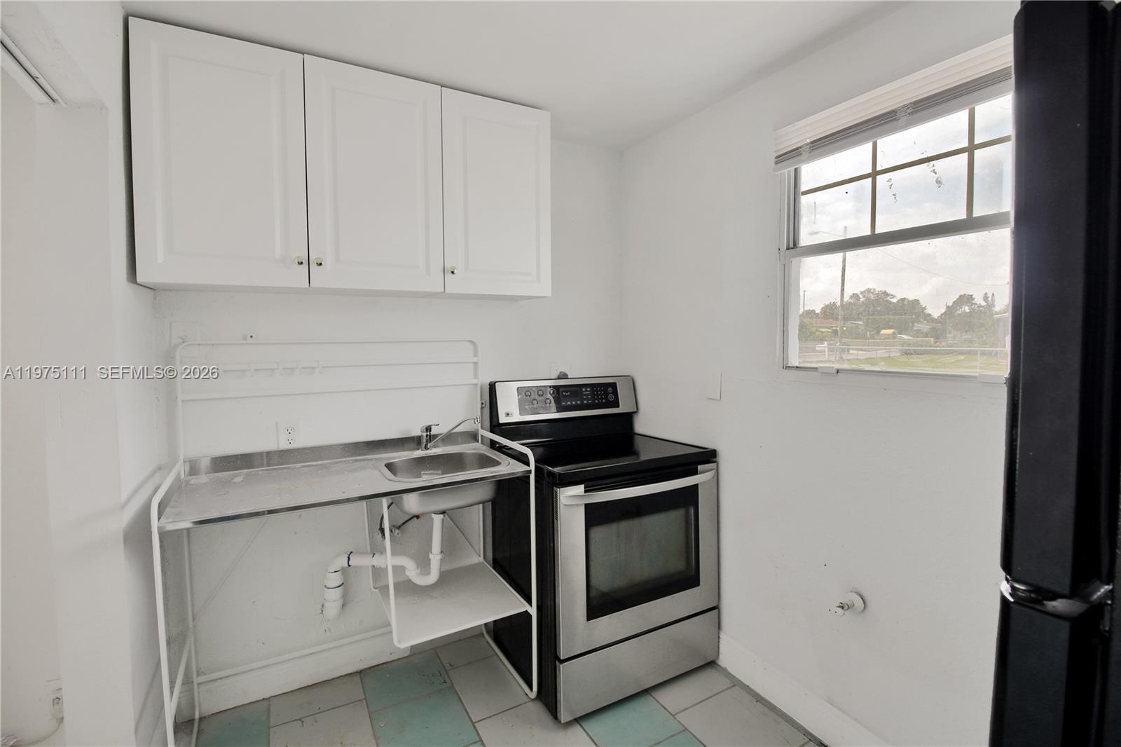 1160 West 26th Court Riviera Beach, FL 33404 - Photo 32 of 40 a stove top oven sitting inside of a kitchen