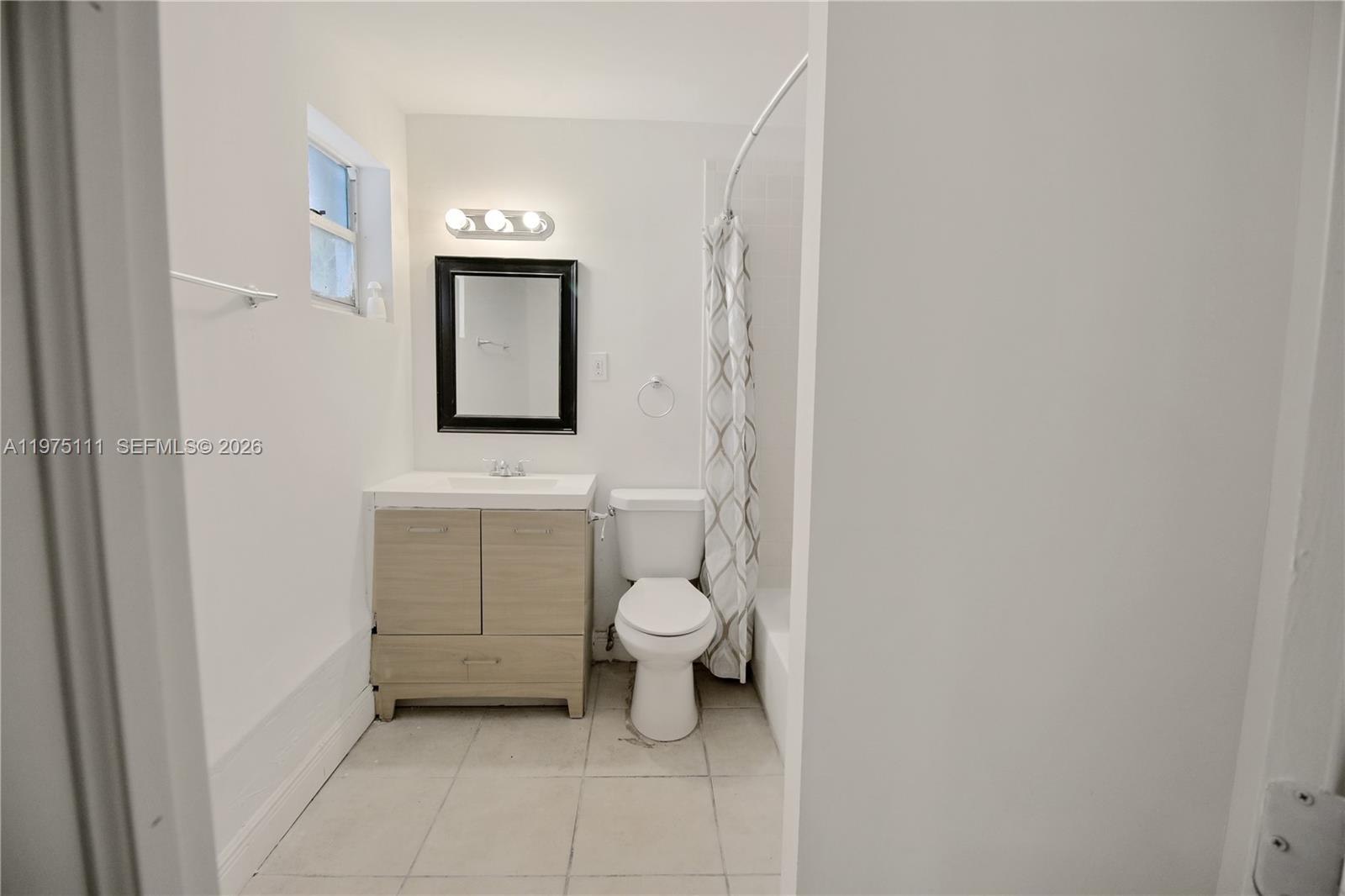1160 West 26th Court Riviera Beach, FL 33404 - Photo 10 of 39 a bathroom with a toilet sink and mirror