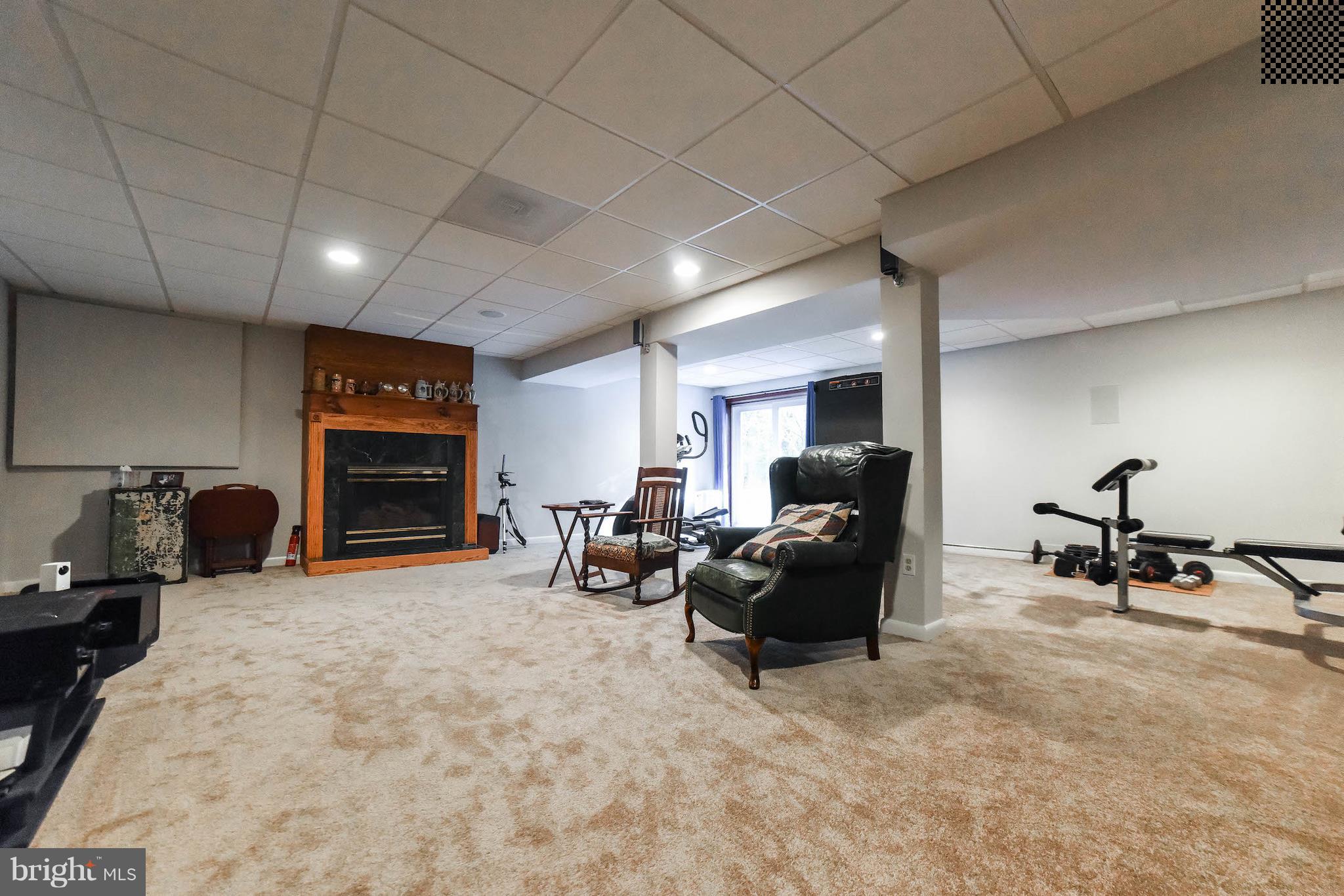 8445 Waverly Road Owings, MD 20736 - Photo 25 of 36 a living room with furniture gym equipment and a fireplace