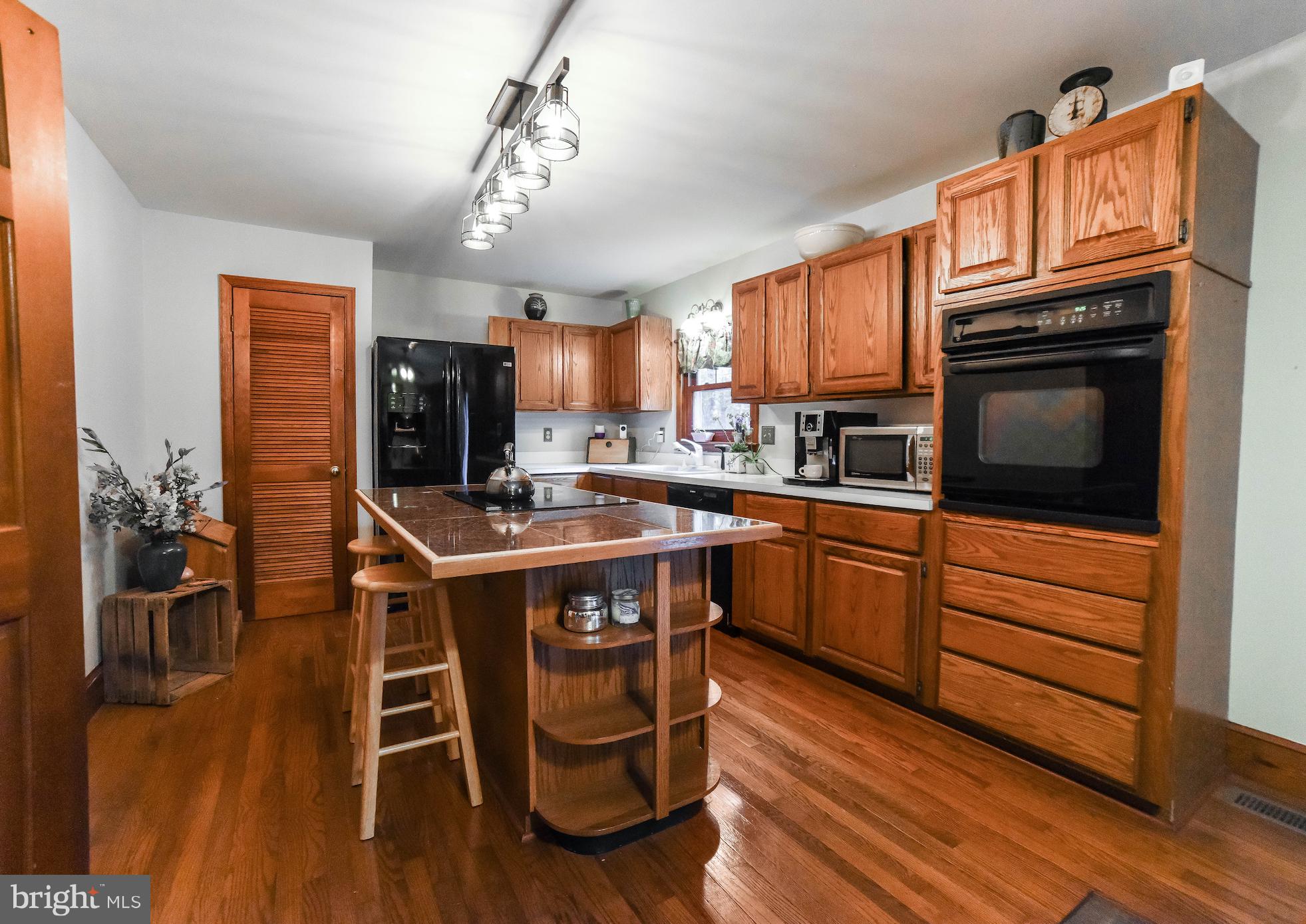 8445 Waverly Road Owings, MD 20736 - Photo 7 of 36 a kitchen with stainless steel appliances granite countertop wooden floors stove top oven and microwave