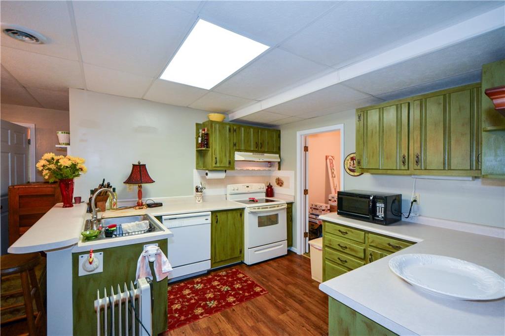 130 Hawn Road Fayetteville, GA 30215 - Photo 32 of 67 a kitchen with a stove a sink dishwasher and a dining table with wooden floor
