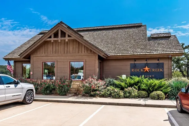 a view of swimming pool with outdoor seating and trees in the background