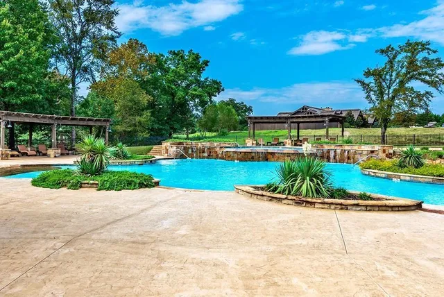 a view of swimming pool with outdoor seating and a garden