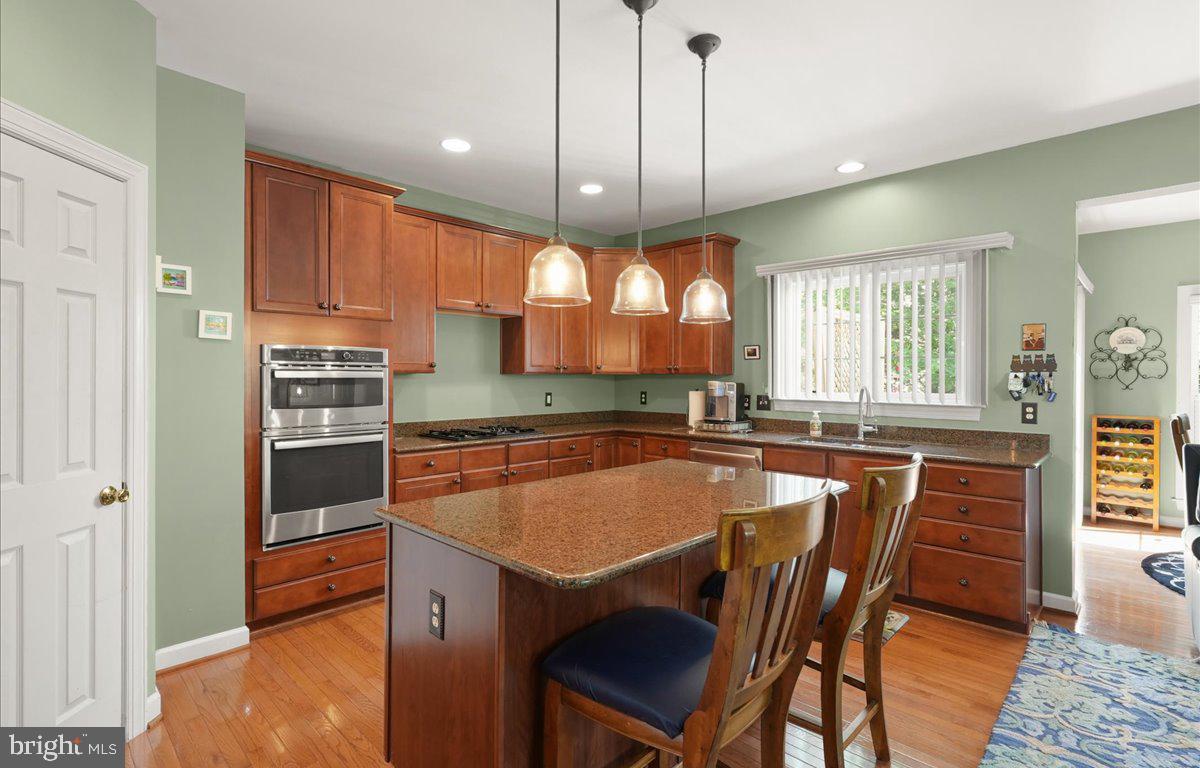 9199 Furey Road Lorton, VA 22079 - Photo 15 of 44 a kitchen with stainless steel appliances granite countertop a sink a stove a table and chairs