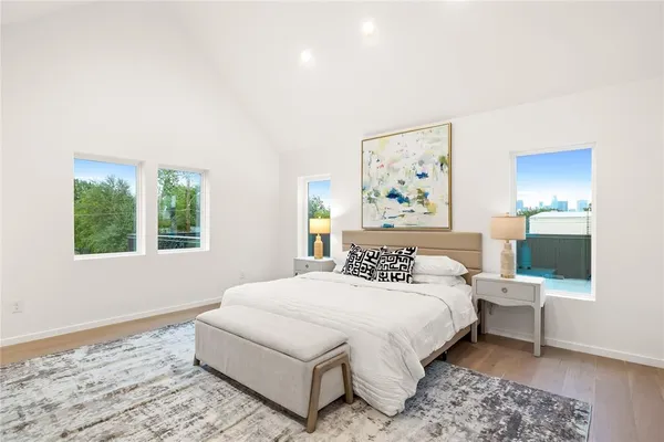 a bedroom with a bed a lamp and a large window