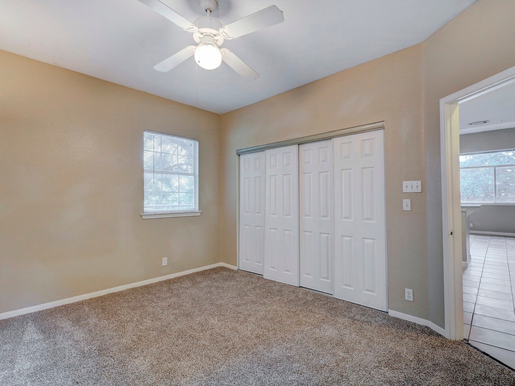 2502 Leon Street, Unit 102 Austin, TX 78705 - Photo 8 of 14 an empty room with a ceiling fan and a window