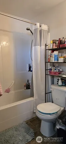 a white toilet and tub sitting next to a bathroom sink