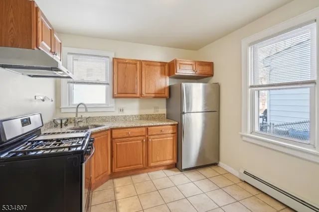 a kitchen with stainless steel appliances granite countertop a refrigerator sink and stove
