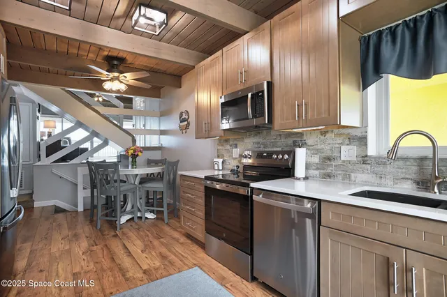 a kitchen with stainless steel appliances granite countertop a sink a stove and cabinets