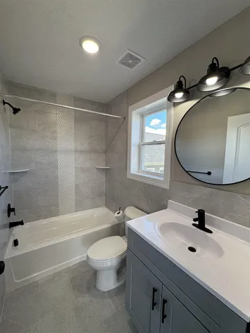 a bathroom with a sink a toilet and a mirror