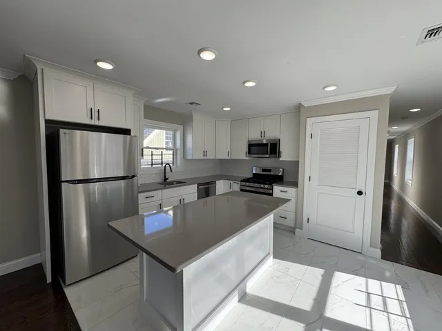 a kitchen with refrigerator cabinets and wooden floor
