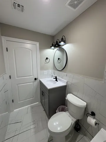 a bathroom with a toilet sink and mirror
