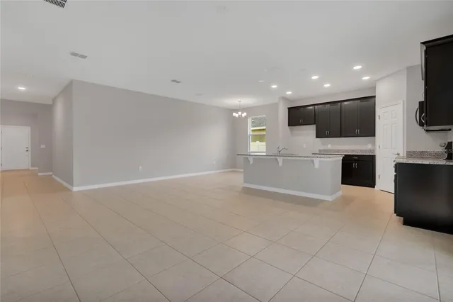 an empty room with chandelier fan