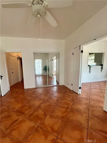 a view of a hallway with a chandelier fan and windows