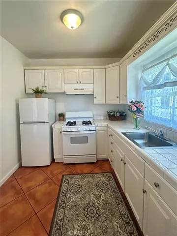 a kitchen with white cabinets and white appliances