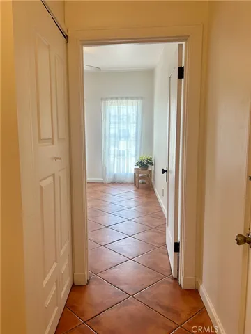 a view of a hallway with wooden floor and a bathroom