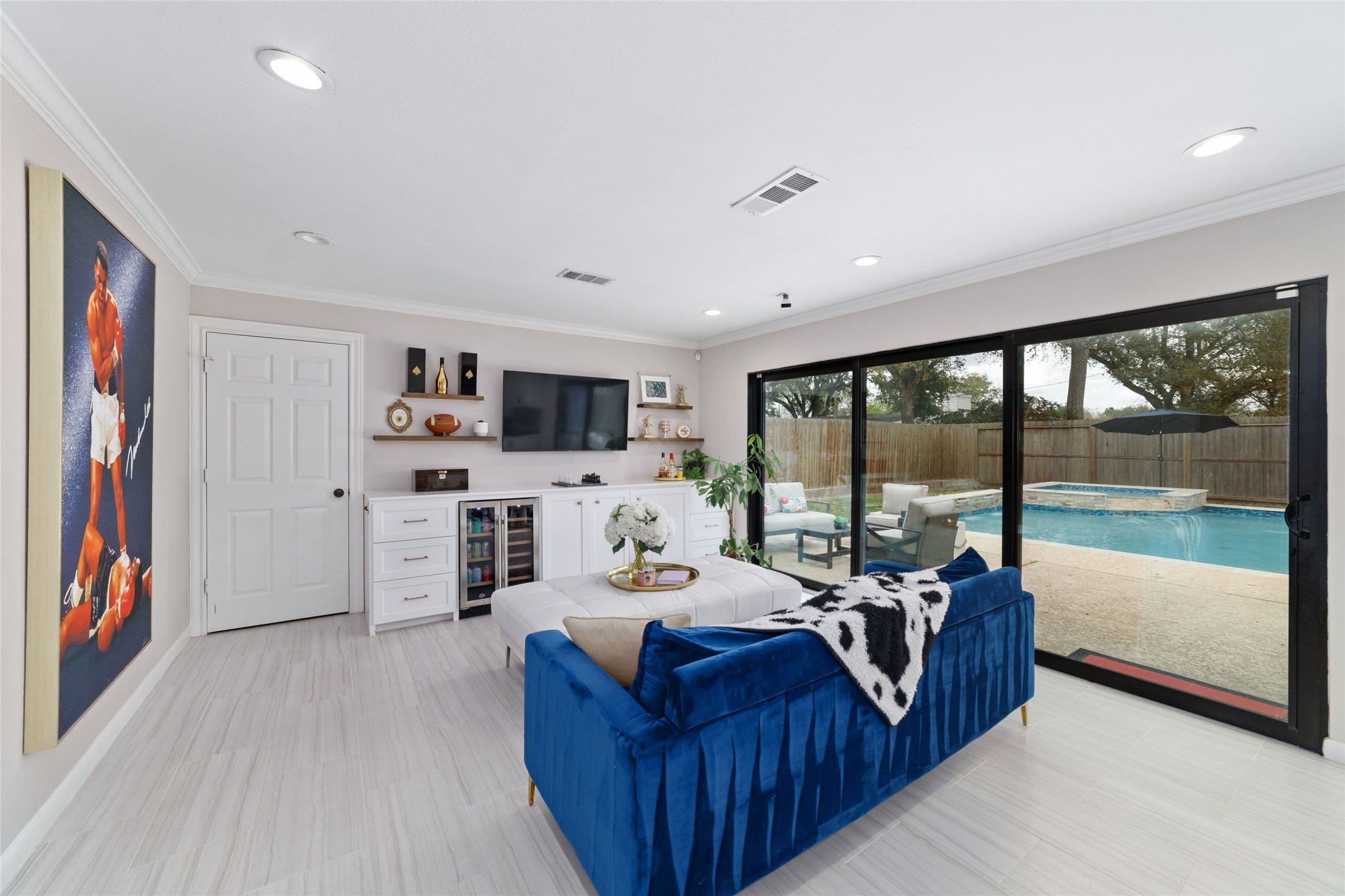 10607 Chimney Rock Road Houston, TX 77096 - Photo 17 of 35 Built-ins with a dual-zone mini fridge, quartz counters, and a drop spot with a drawer to keep chargers and electronics out of sight. Porcelain tile floors are easy to maintain, recessed can lighting keeps it bright, and there’s plenty of cabinet and drawer storage. This room flexes… lounge, media, or work space… and opens right out to the pool when you want it to.