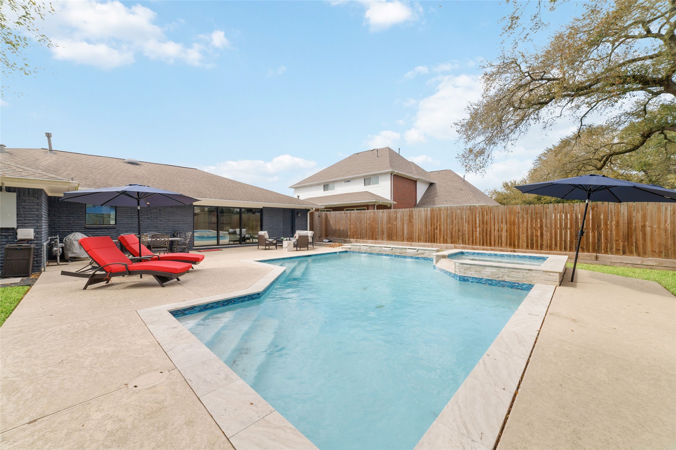 10607 Chimney Rock Road Houston, TX 77096 - Photo 32 of 35 Saltwater pool and spa, heated and easy to maintain. Clean layout with space around it so it never feels tight. This is where you’ll spend your time with cool deck and umbrella grips spaced around the pool.