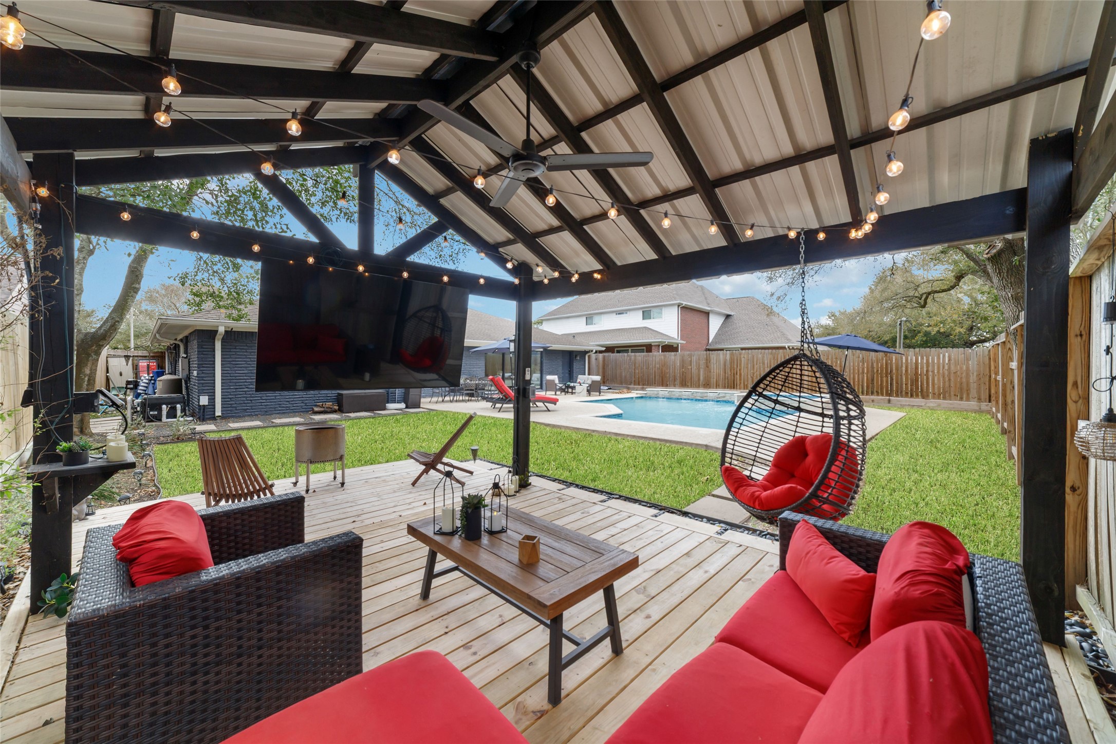 10607 Chimney Rock Road Houston, TX 77096 - Photo 8 of 35 Catch the Texans on the big screen from your own backyard tailgate, under the stars and warm strings of patio lights. Grill going, pool lit, waterfall running in the background while the sun drops over your own quiet, zen landscape. This isn’t an Airbnb… it’s your home, your WFH paradise, and honestly you might start calling in “working from here” a little more than usual.