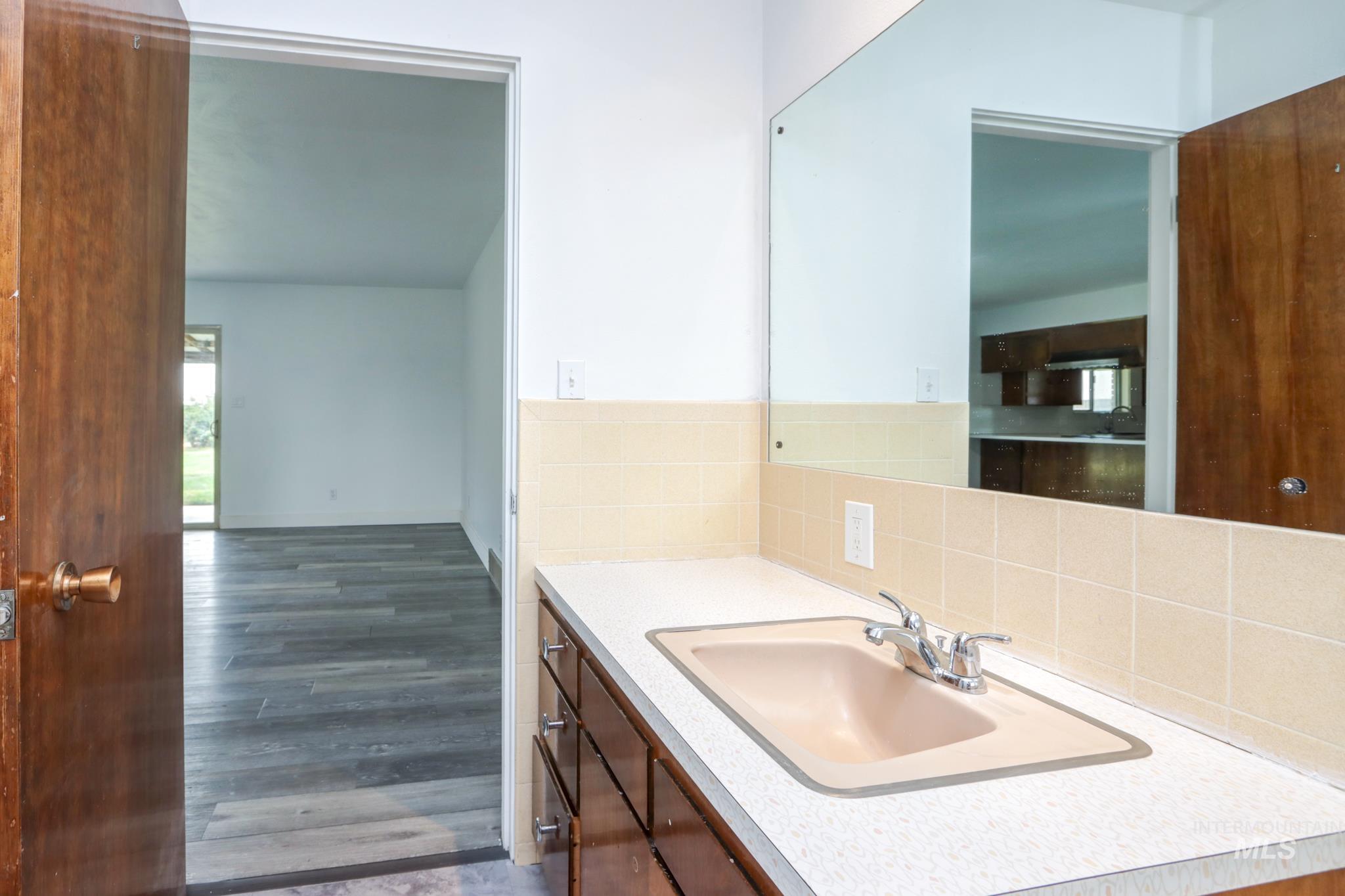 801 Thompson Avenue Nyssa, OR 97913 - Photo 24 of 46 Bathroom vanity with a built-in sink, laminate countertop, and tiled backsplash