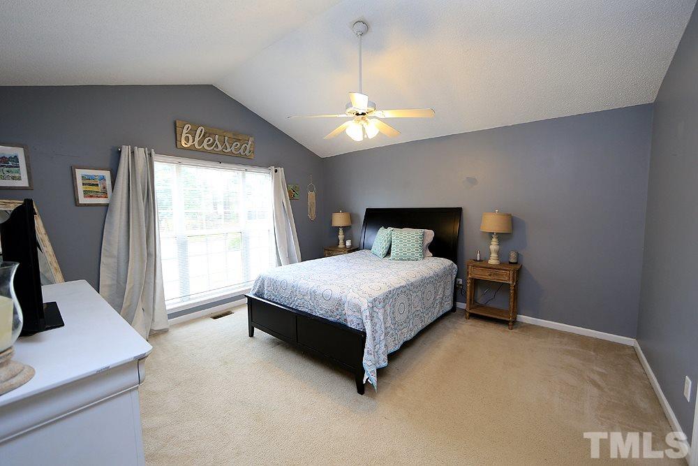 409 Flagg Road Holly Springs, NC 27540 - Photo 6 of 14 The large master bedroom features a vaulted ceiling, ceiling fan and walk in closet.