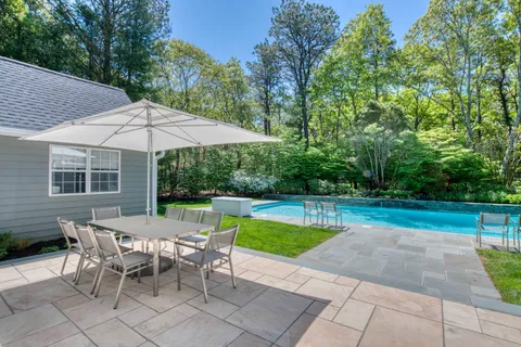 a view of backyard with swimming pool and patio