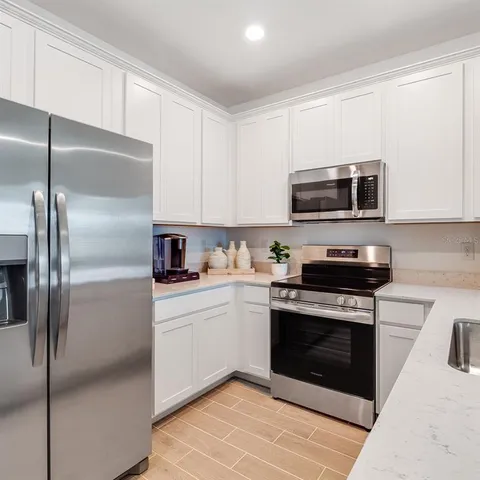 a view of a house with a yard and a large tree