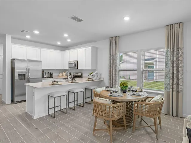 a kitchen with a refrigerator stove and white cabinets