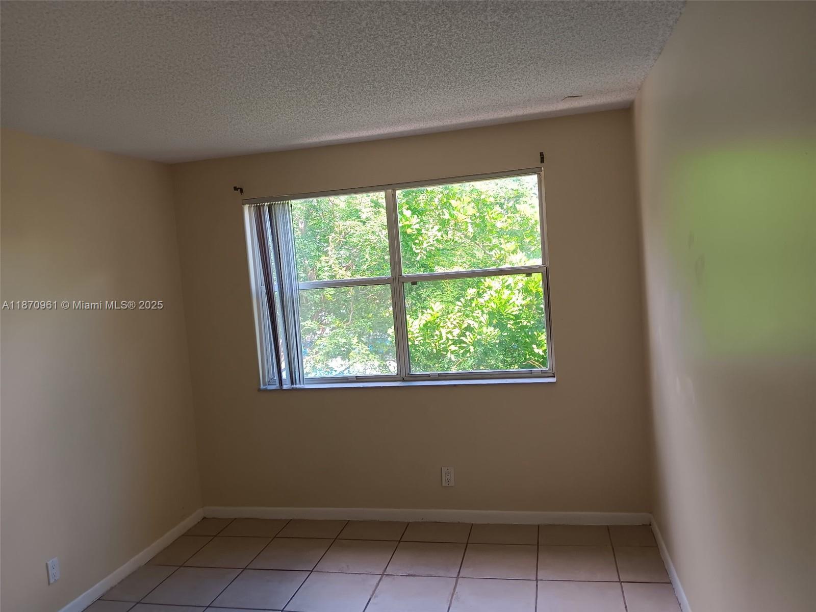 8821 Wiles Road, Unit 308 Coral Springs, FL 33067 - Photo 12 of 18 an empty room with a window