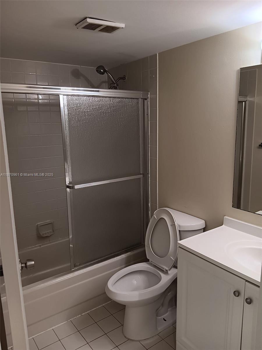 8821 Wiles Road, Unit 308 Coral Springs, FL 33067 - Photo 13 of 18 a bathroom with a granite countertop toilet and a shower