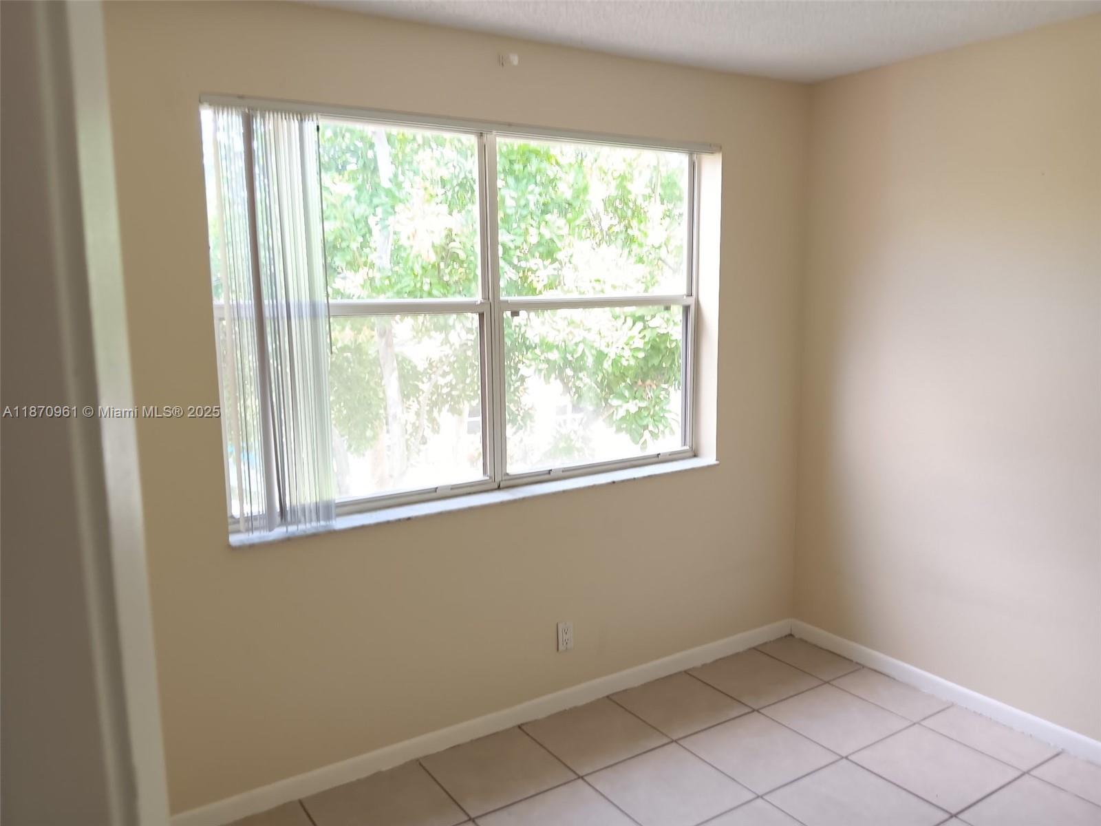 8821 Wiles Road, Unit 308 Coral Springs, FL 33067 - Photo 15 of 18 an empty room with a window