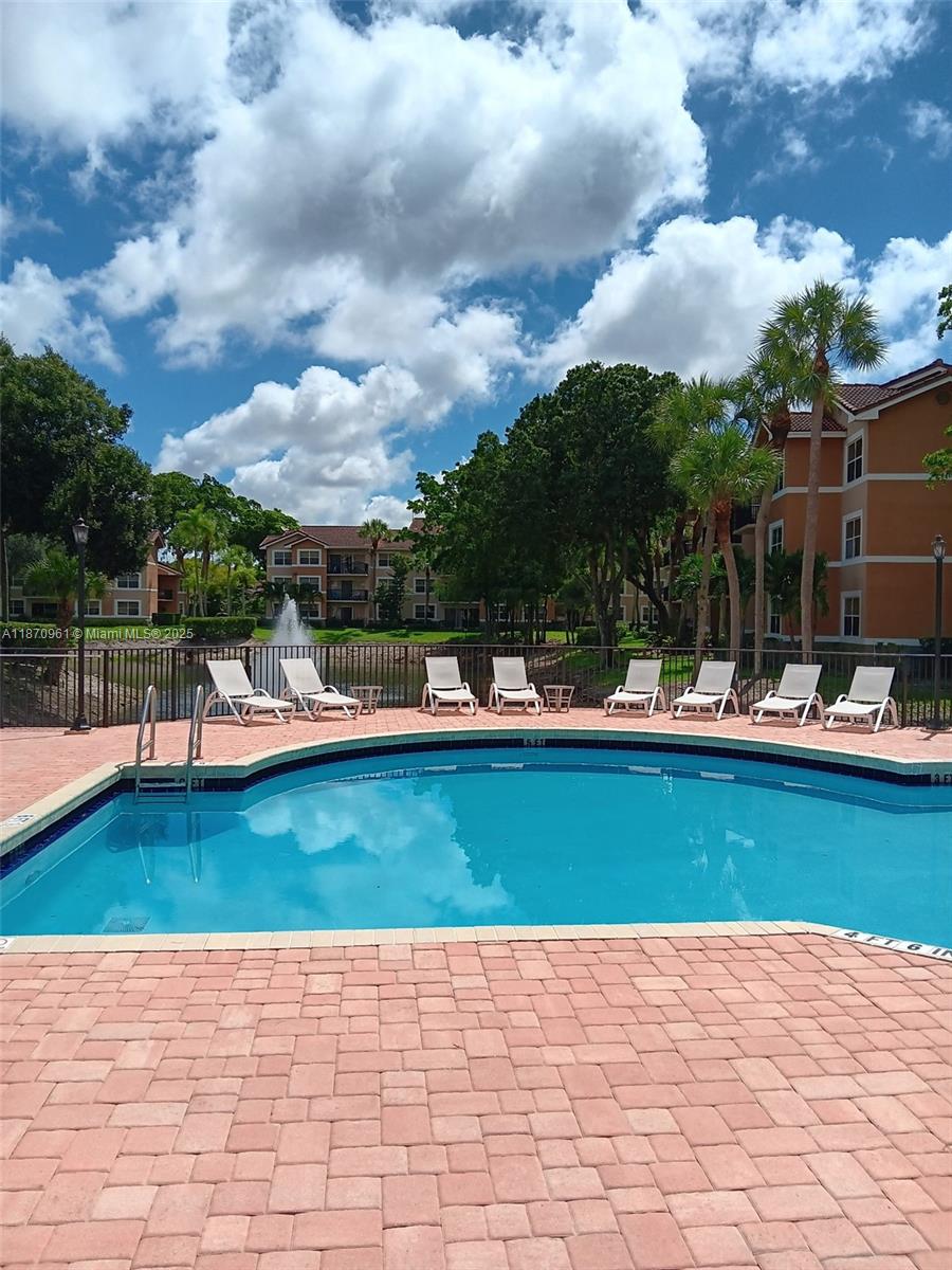 8821 Wiles Road, Unit 308 Coral Springs, FL 33067 - Photo 16 of 18 a view of swimming pool with outdoor seating and plants