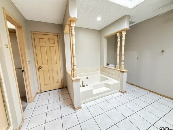 a spacious bathroom with a tub shower and a sink