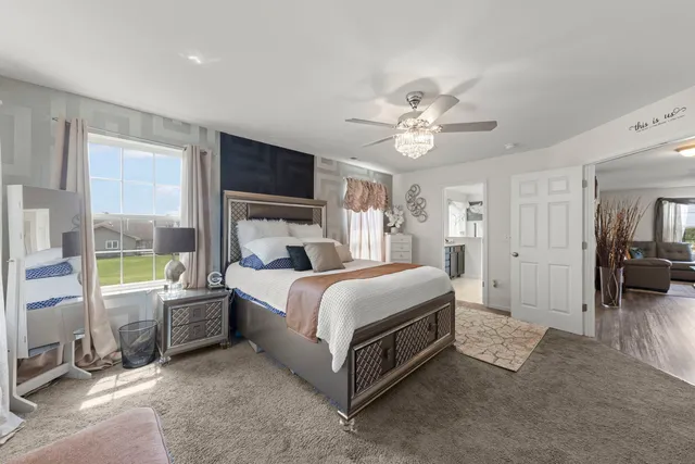 a spacious bedroom with a bed a fireplace and a large window