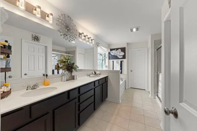 a bathroom with a double vanity sink mirror and refrigerator