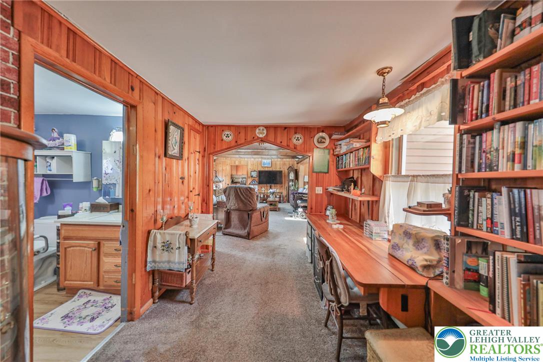 331 Cranberry Creek Road Cresco, PA 18326 - Photo 22 of 95 An inviting room features warm wood paneling, built-in shelving, and a clear view into an adjacent living area.